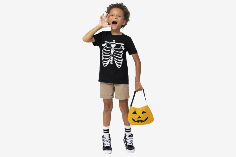 Menino usando camiseta infantil de Halloween e bolsa de abóbora