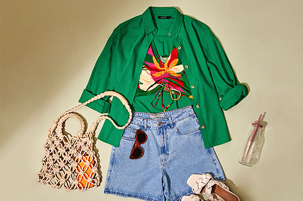 Peças de look de verão: shorts jeans, camisa verde, bolsa de praia e óculos de sol