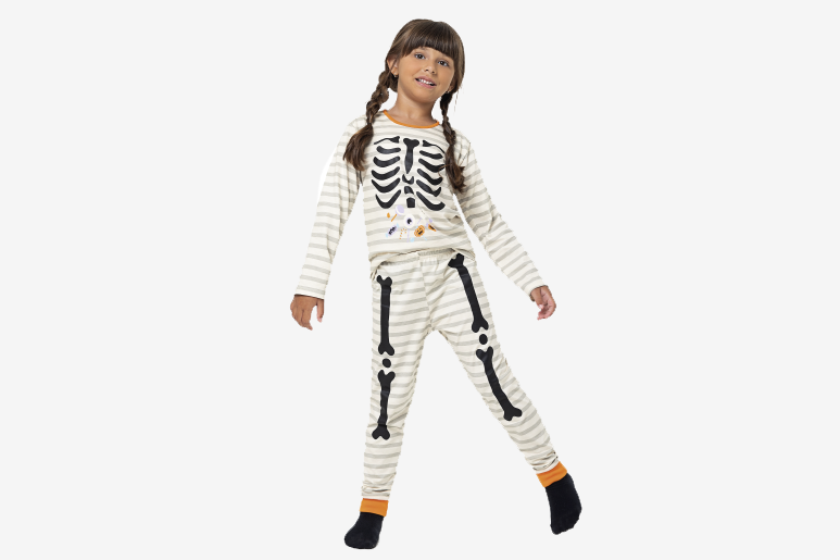 Menina usando pijama de esqueleto temático de Halloween