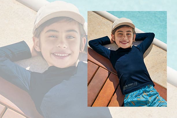 Criança veste boné off-white, camiseta de praia Me Encontre com proteção solar UV50+ e sunga infantil. Todas as peças são da coleção de Alto Verão 2025-2026 da Malwee Kids.