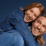 Casal sorridente usando looks jeans em clima descontraído, representando conexão e principais dúvidas sobre jeans no dia a dia