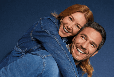 Casal sorridente usando looks jeans em clima descontraído, representando conexão e principais dúvidas sobre jeans no dia a dia