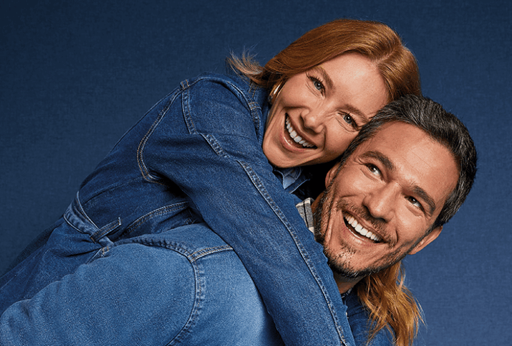 Casal sorridente usando looks jeans em clima descontraído, representando conexão e principais dúvidas sobre jeans no dia a dia
