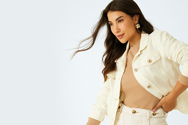 Mulher elegante com jaqueta e calça jeans off-white, representando estilo e principais dúvidas sobre jeans claros